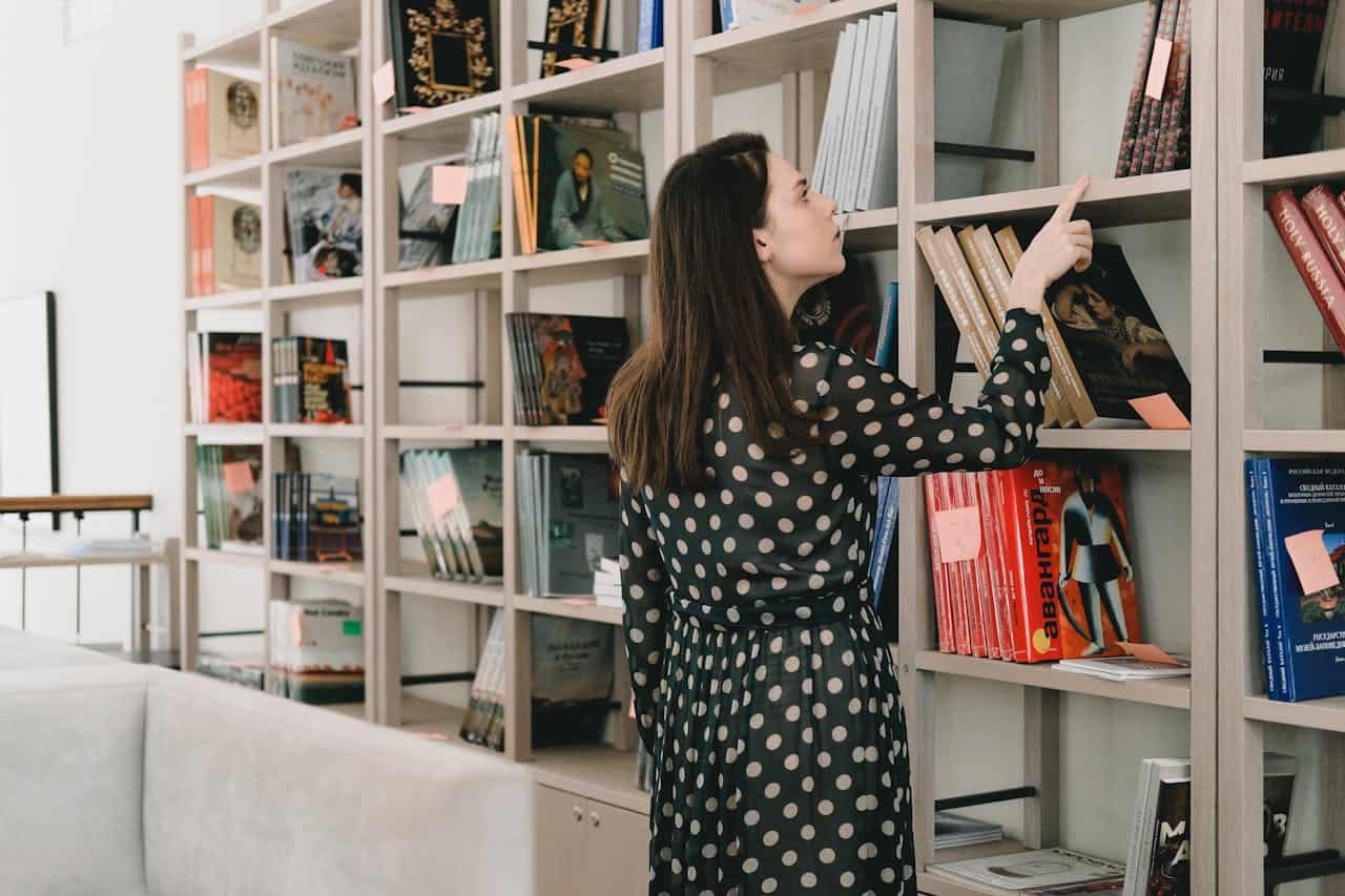 Woman choosing book from bookshelf