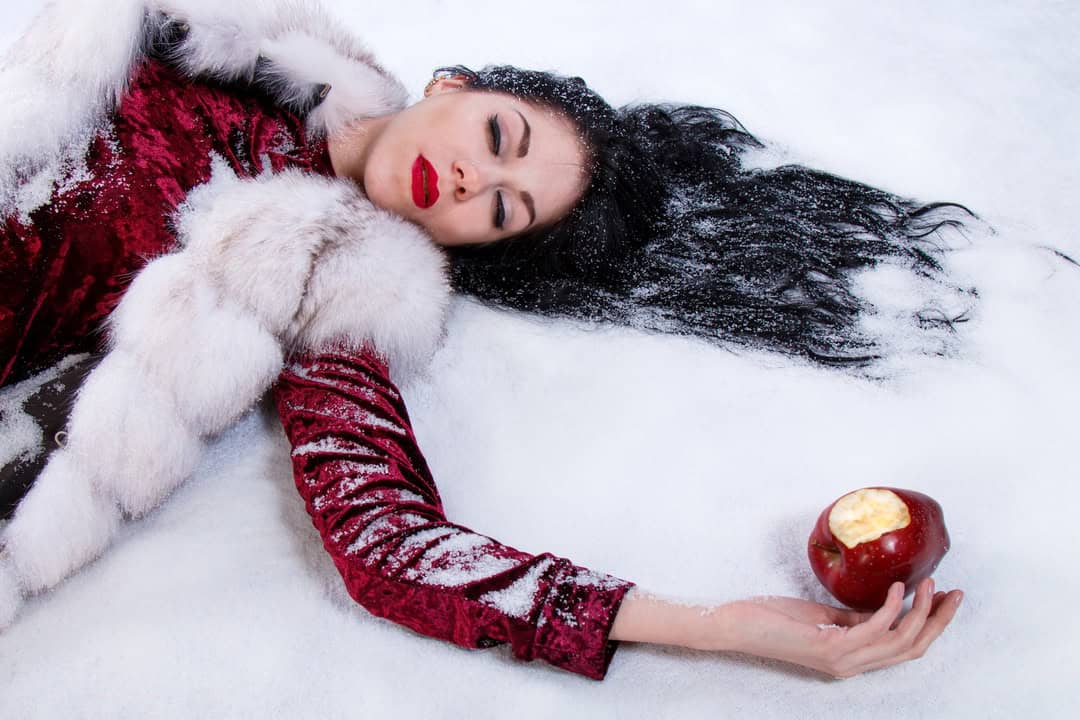 Snowhite laying on the ground after eating the poisoned apple